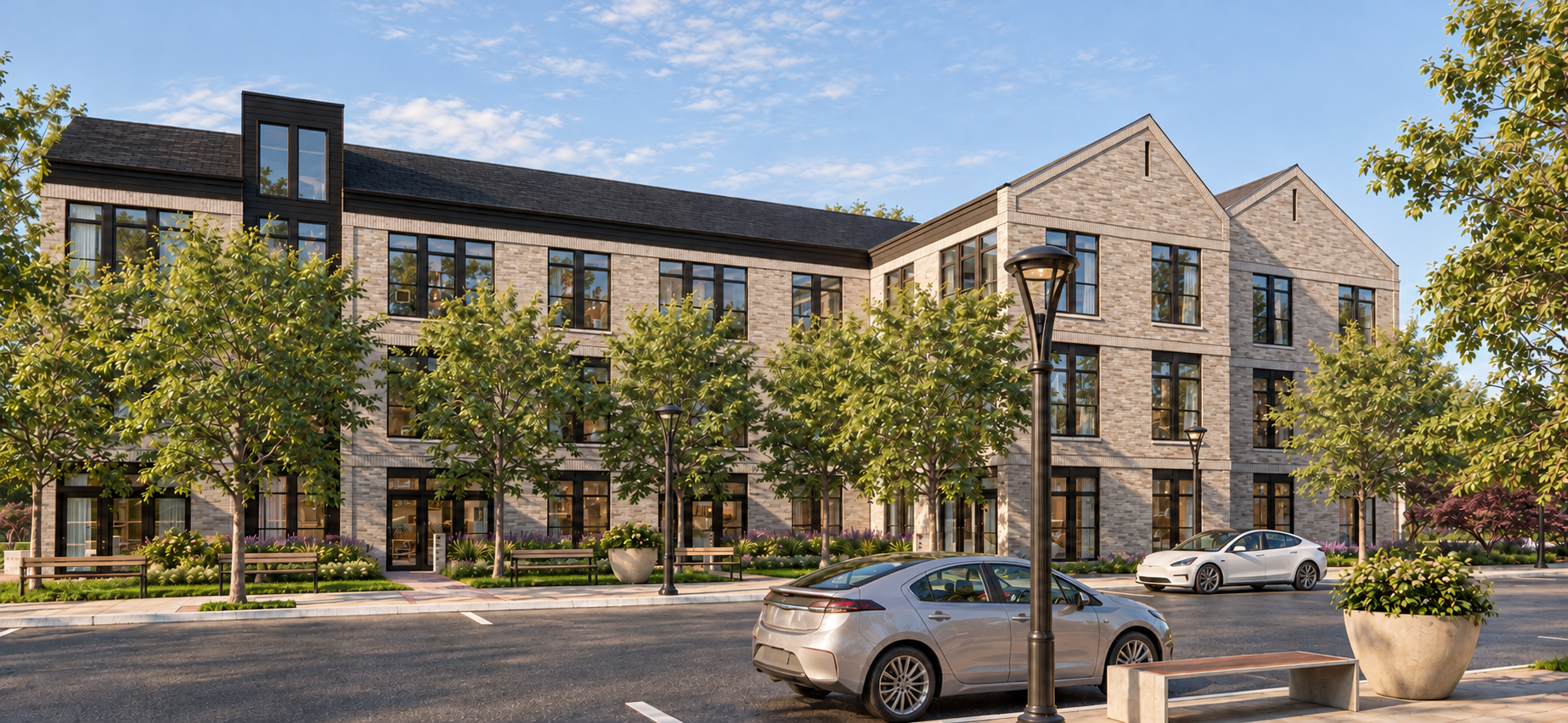 Three-story Rivulet multifamily building in light brick with dark gabled bays, shaded sidewalks, and landscaped walkways